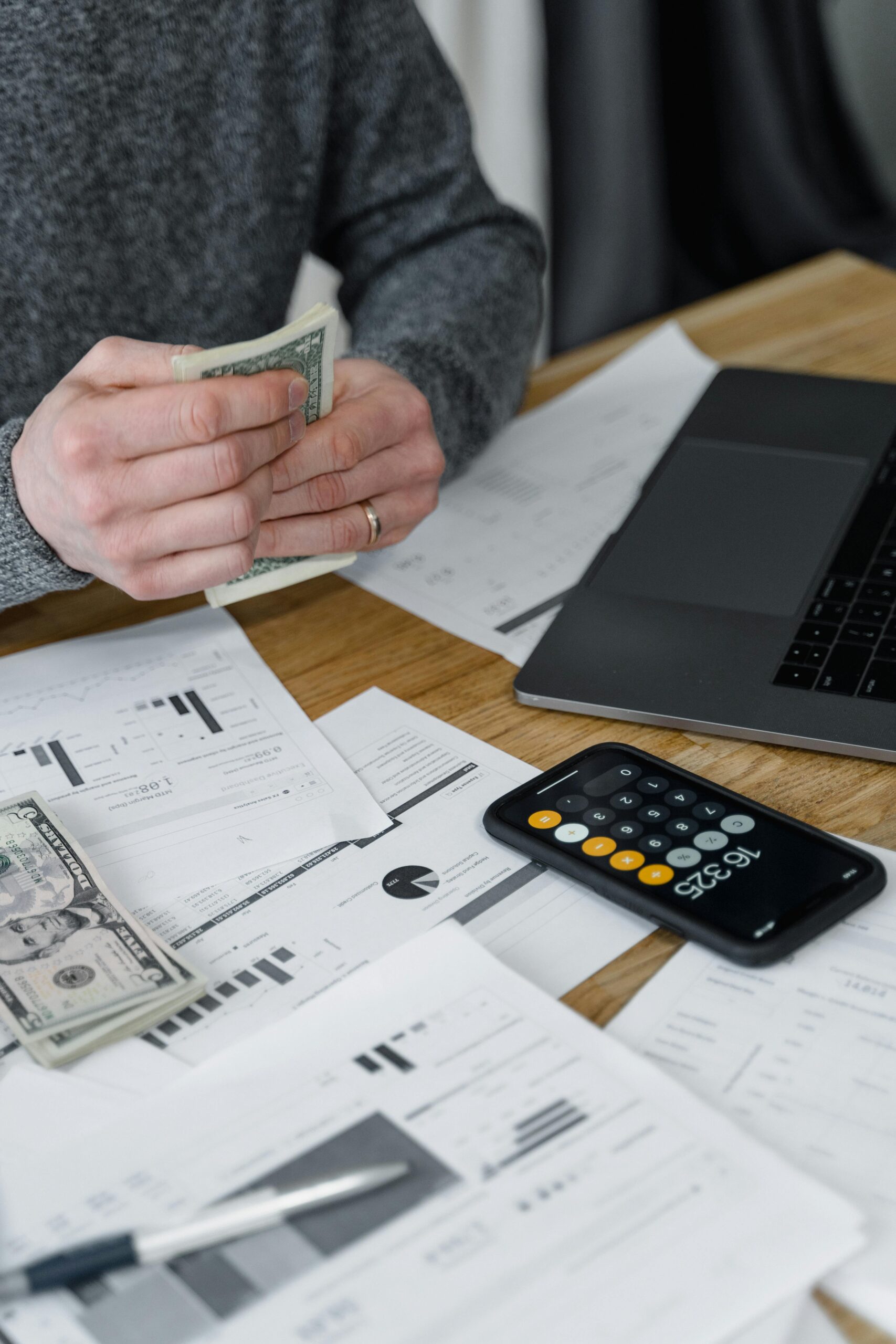 A workspace with a laptop, calculator, and receipts used for reconciling accounts during QuickBooks setup cleanup.