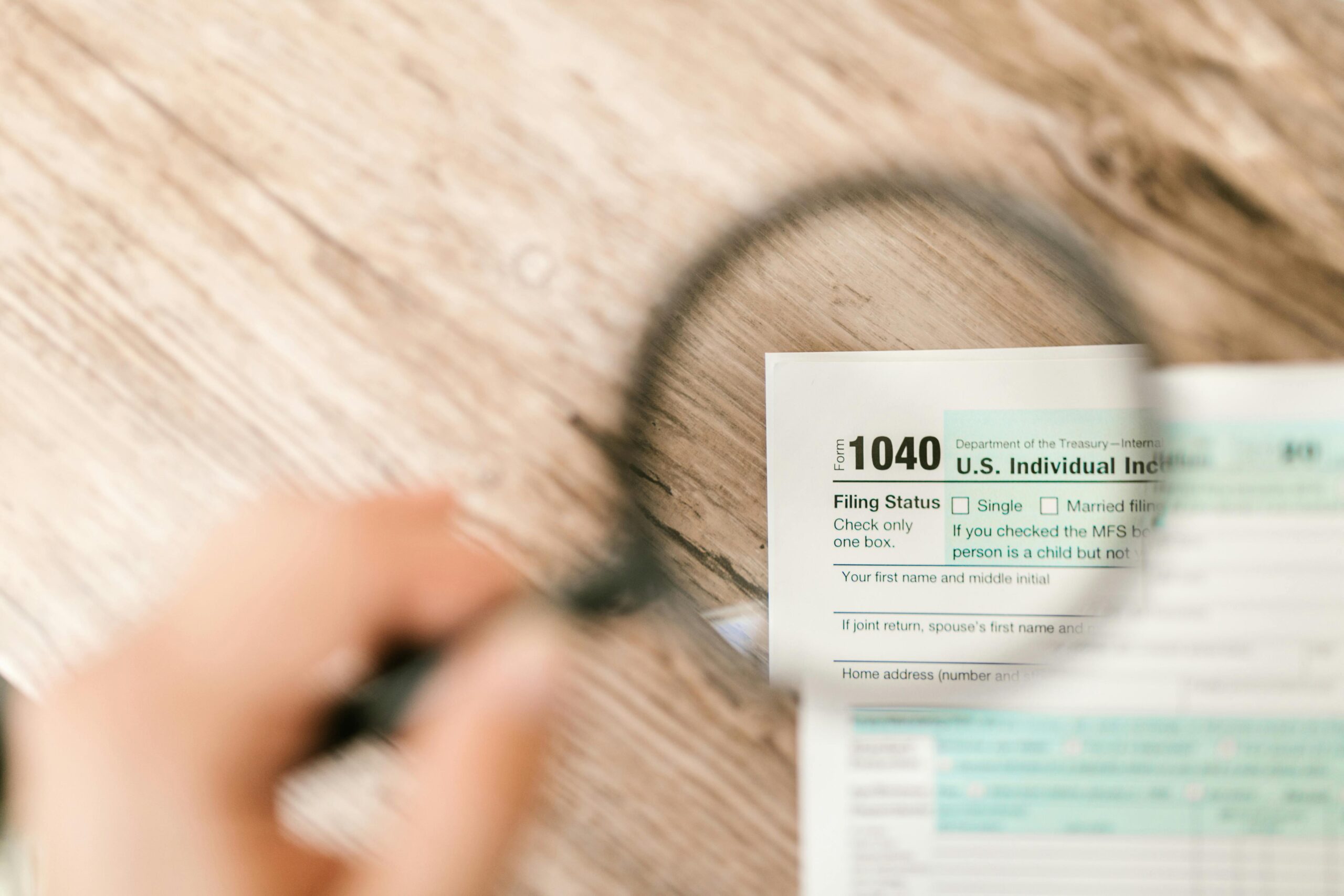 Payroll support reporting and year-end payroll review with magnifying glass examining payroll documents
